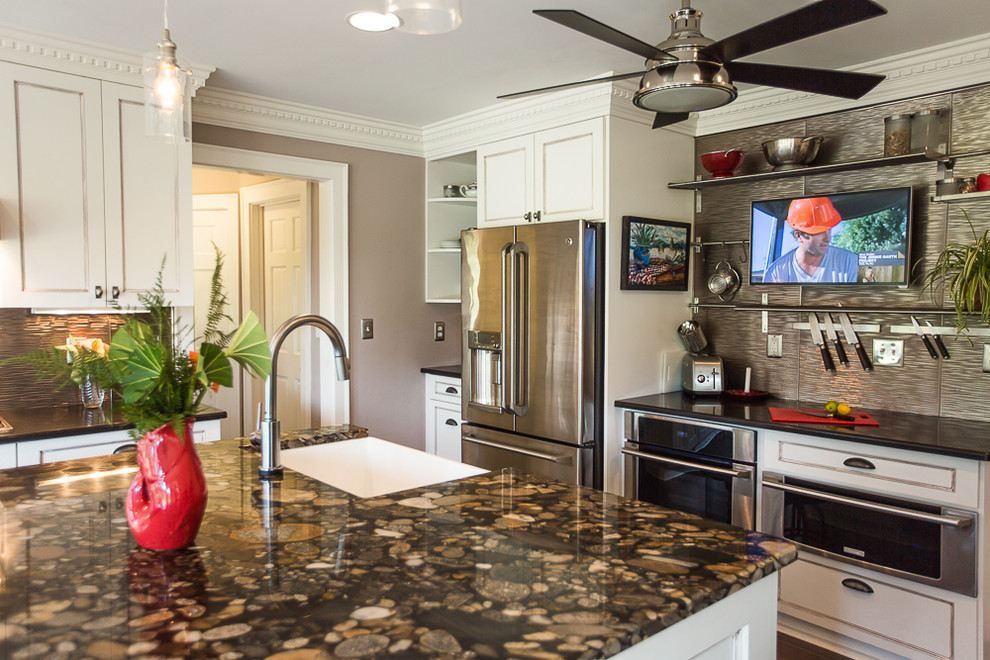 Example of a mid-sized transitional u-shaped enclosed kitchen design in Other with a farmhouse sink, recessed-panel cabinets, white cabinets, granite countertops, metallic backsplash, metal backsplash, stainless steel appliances and an island