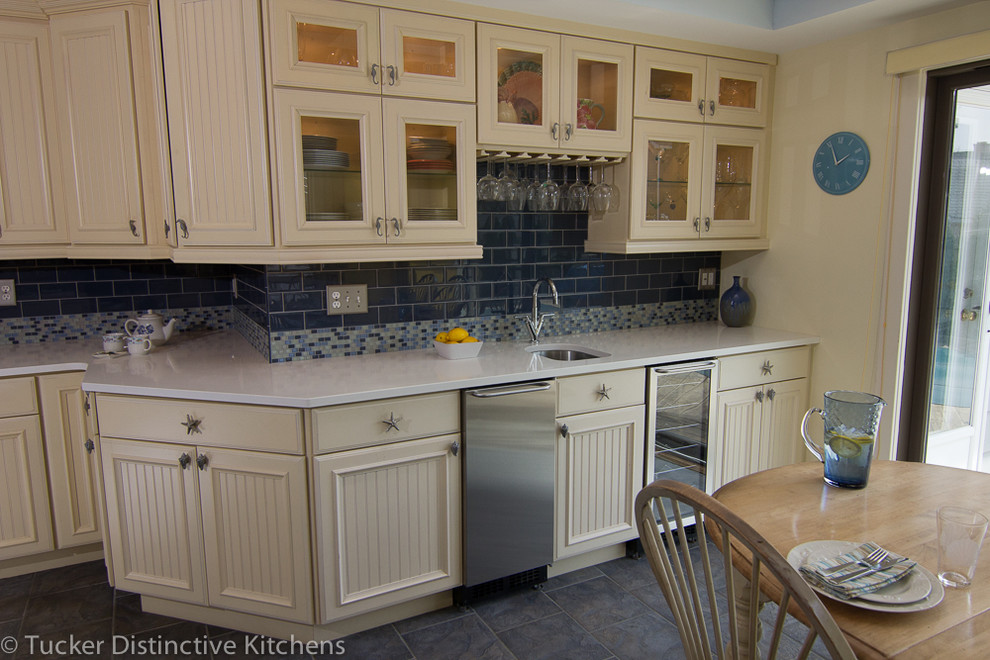 Photo of a beach style kitchen in Charleston with beaded cabinets, yellow cabinets, quartz worktops, blue splashback, stainless steel appliances and an island.