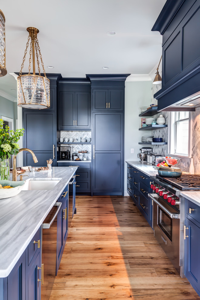 Inspiration for a large traditional l-shaped kitchen/diner in New York with a submerged sink, recessed-panel cabinets, blue cabinets, granite worktops, multi-coloured splashback, porcelain splashback, stainless steel appliances, medium hardwood flooring, an island, brown floors and grey worktops.