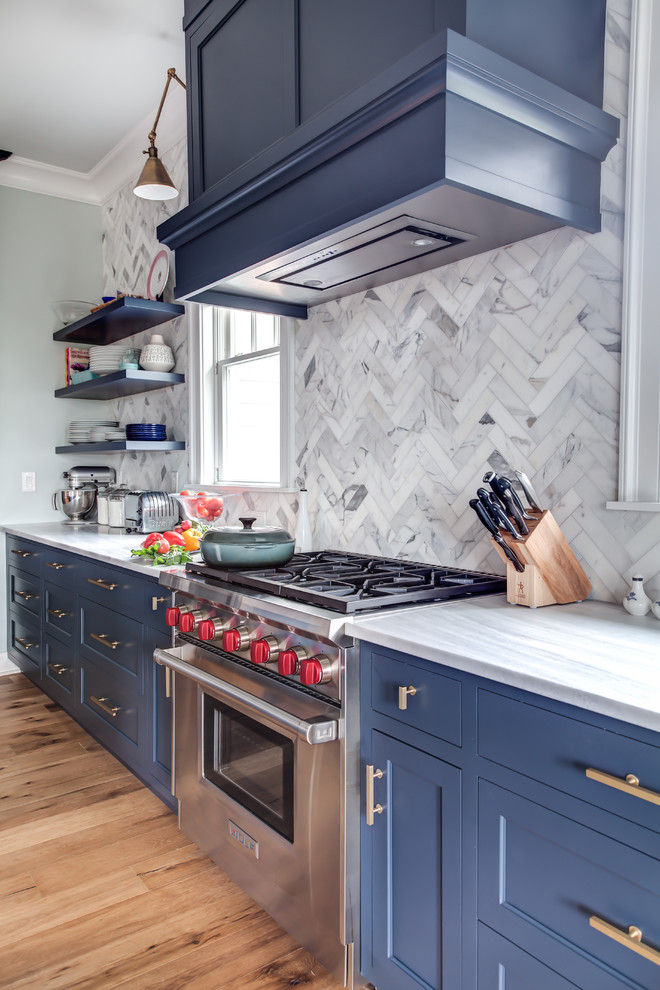 Inspiration for a large transitional l-shaped medium tone wood floor and brown floor eat-in kitchen remodel in New York with an undermount sink, recessed-panel cabinets, blue cabinets, granite countertops, multicolored backsplash, porcelain backsplash, stainless steel appliances, an island and gray countertops