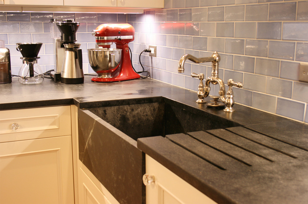 Kitchen - contemporary kitchen idea in Boston with soapstone countertops, a farmhouse sink and blue backsplash