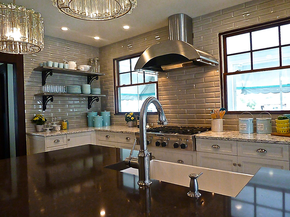 Exempel på ett stort klassiskt kök, med en rustik diskho, luckor med infälld panel, vita skåp, granitbänkskiva, grått stänkskydd, stänkskydd i tunnelbanekakel, rostfria vitvaror, klinkergolv i porslin, en köksö och brunt golv