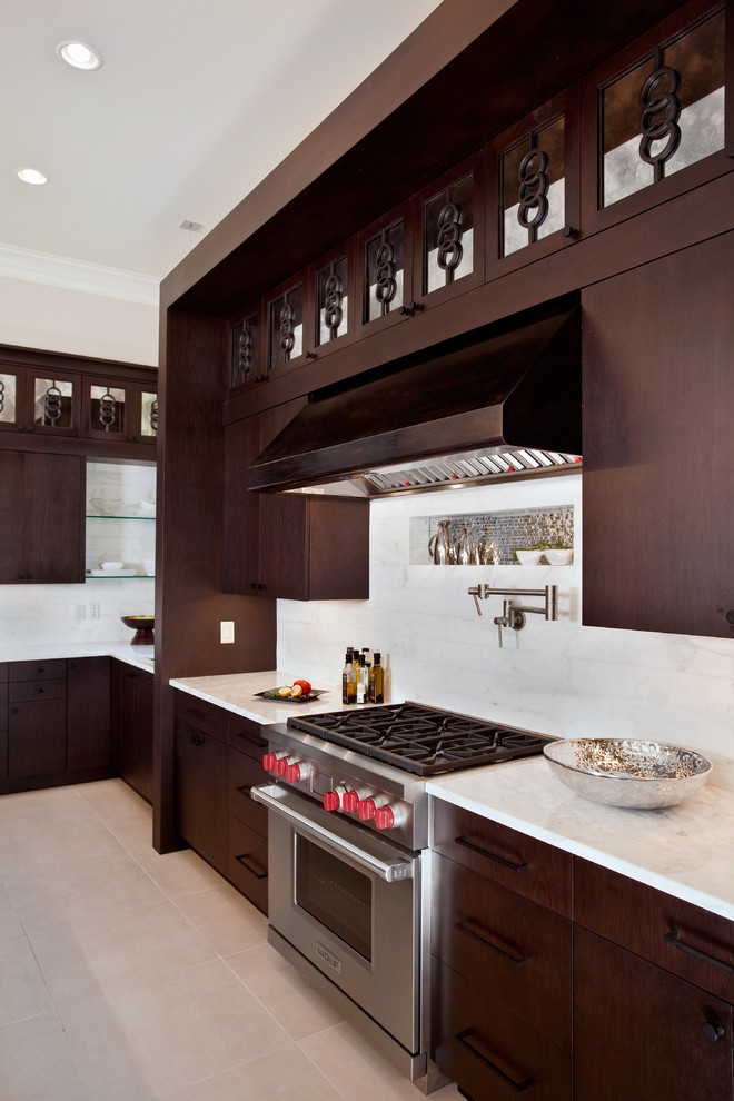 Moderne Küche mit Küchengeräten aus Edelstahl, Marmor-Arbeitsplatte, flächenbündigen Schrankfronten, dunklen Holzschränken und Rückwand aus Marmor in Miami