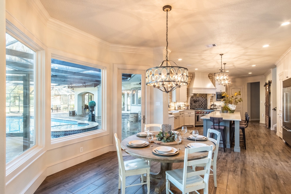Eat-in kitchen - large galley porcelain tile and brown floor eat-in kitchen idea in Houston with a farmhouse sink, shaker cabinets, white cabinets, quartzite countertops, multicolored backsplash, stone tile backsplash, stainless steel appliances, an island and multicolored countertops