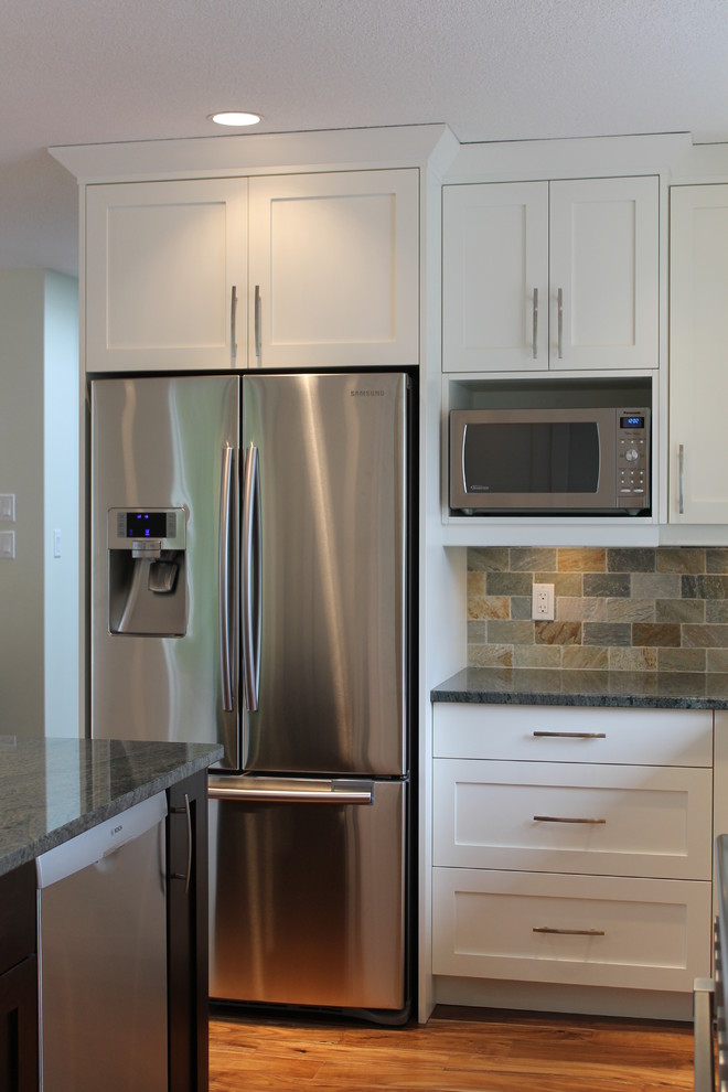 Exempel på ett mellanstort klassiskt kök, med en undermonterad diskho, skåp i shakerstil, vita skåp, granitbänkskiva, flerfärgad stänkskydd, stänkskydd i stenkakel, rostfria vitvaror, mellanmörkt trägolv och en köksö