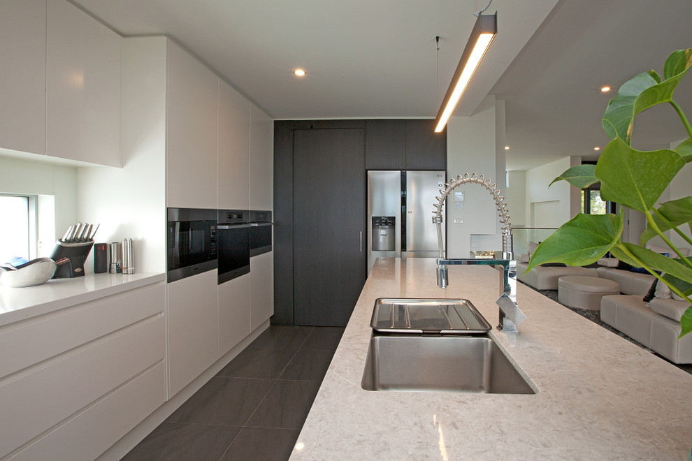 Immagine di una cucina minimal di medie dimensioni con lavello stile country, ante bianche, top in marmo e elettrodomestici in acciaio inossidabile