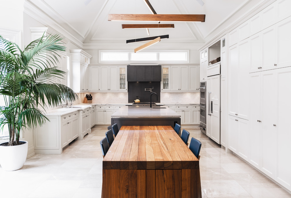 Inspiration for a large traditional u-shaped kitchen in Toronto with white cabinets, white splashback, integrated appliances, multiple islands, white floors, white worktops and beaded cabinets.