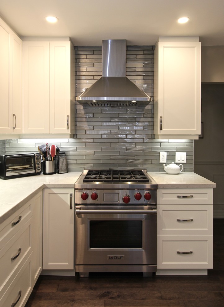 Inspiration for a mid-sized contemporary u-shaped medium tone wood floor and brown floor open concept kitchen remodel in Toronto with an undermount sink, recessed-panel cabinets, white cabinets, quartz countertops, gray backsplash, glass tile backsplash, stainless steel appliances and a peninsula