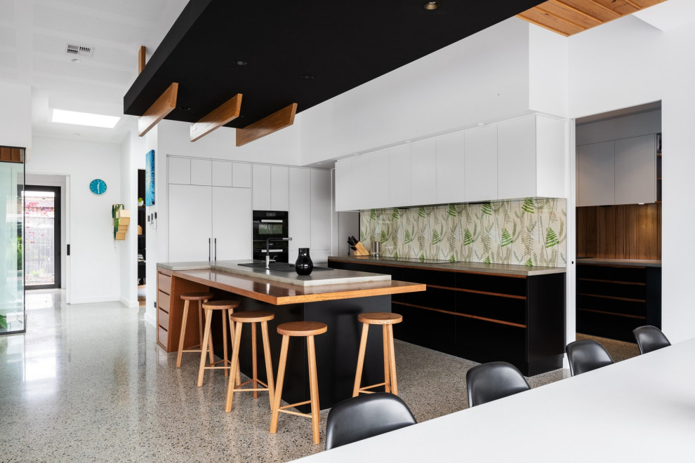 Offene Moderne Küche mit flächenbündigen Schrankfronten, weißen Schränken, bunter Rückwand, schwarzen Elektrogeräten, Kücheninsel, buntem Boden und grüner Arbeitsplatte in Canberra - Queanbeyan