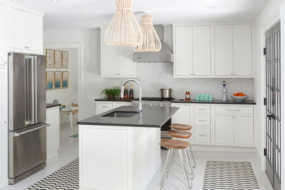 Mid-sized beach style l-shaped painted wood floor and white floor kitchen photo in New York with an undermount sink, shaker cabinets, white cabinets, granite countertops, white backsplash, mosaic tile backsplash, stainless steel appliances and an island