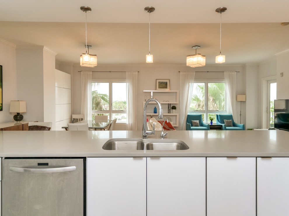 Immagine di una cucina minimalista di medie dimensioni con ante lisce, ante bianche, top in quarzo composito, penisola e top grigio