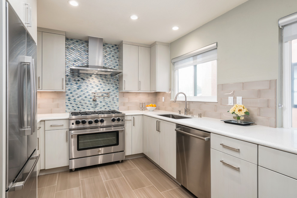 Example of a mid-sized trendy u-shaped ceramic tile open concept kitchen design in San Francisco with an undermount sink, flat-panel cabinets, gray cabinets, quartz countertops, blue backsplash, glass tile backsplash, stainless steel appliances and a peninsula