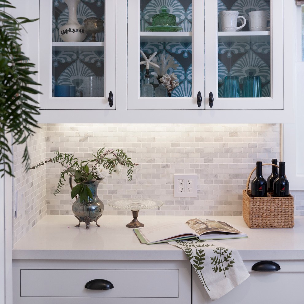 Maritime Wohnküche mit Küchenrückwand in Weiß, Küchengeräten aus Edelstahl, braunem Holzboden, Kücheninsel, braunem Boden und weißer Arbeitsplatte in Orange County