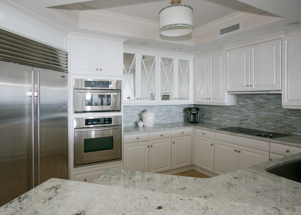 Inspiration for a small transitional u-shaped ceramic tile and beige floor open concept kitchen remodel in Jacksonville with an undermount sink, raised-panel cabinets, white cabinets, marble countertops, blue backsplash, glass tile backsplash, stainless steel appliances and no island
