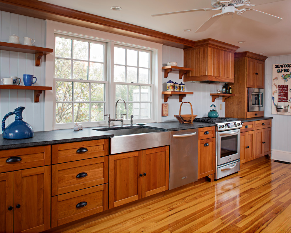 Exempel på ett mellanstort klassiskt kök, med en rustik diskho, luckor med infälld panel, skåp i ljust trä, granitbänkskiva, blått stänkskydd, rostfria vitvaror, ljust trägolv och brunt golv