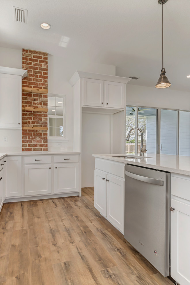 Medium sized traditional l-shaped enclosed kitchen in Jacksonville with a submerged sink, shaker cabinets, white cabinets, engineered stone countertops, dark hardwood flooring, an island, brown floors and white worktops.