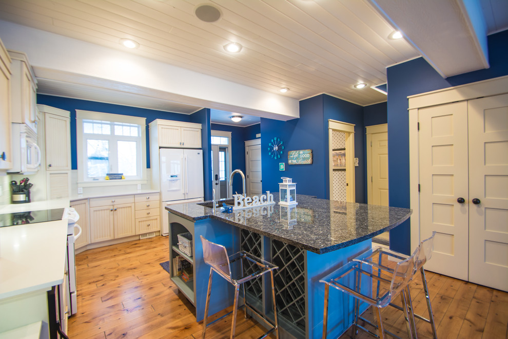 Eat-in kitchen - mid-sized traditional l-shaped medium tone wood floor and brown floor eat-in kitchen idea with a double-bowl sink, recessed-panel cabinets, blue cabinets, granite countertops, gray backsplash, subway tile backsplash, white appliances and an island