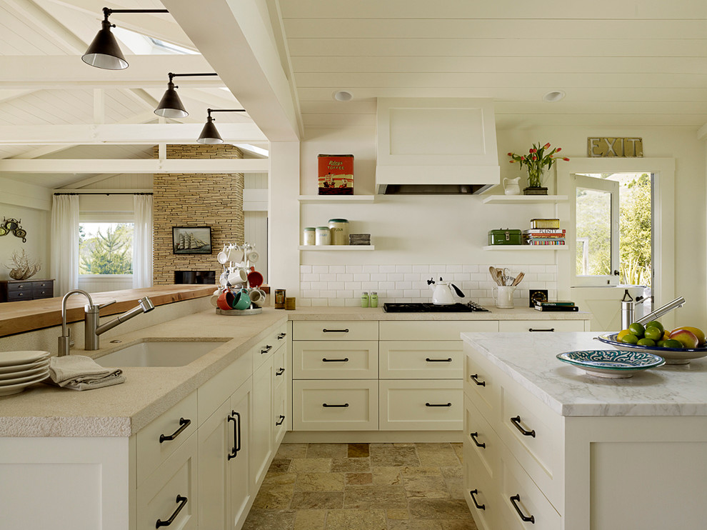 This is an example of a large nautical u-shaped open plan kitchen in San Francisco with a submerged sink, shaker cabinets, white cabinets, quartz worktops, white splashback, metro tiled splashback, stainless steel appliances, ceramic flooring, an island and beige floors.