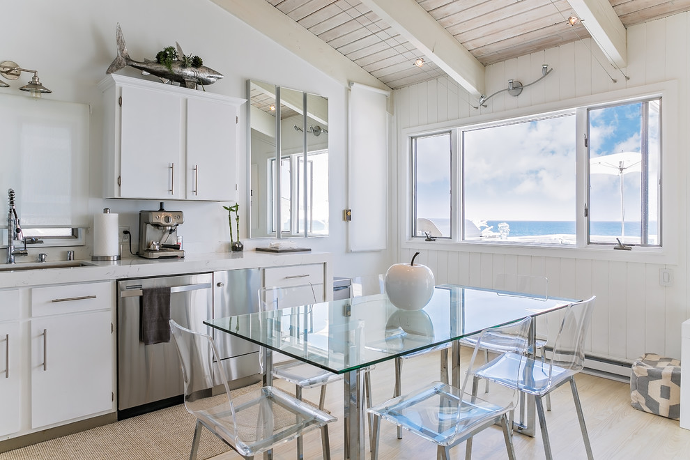 Foto de cocina comedor marinera de tamaño medio con suelo de madera clara, fregadero bajoencimera, puertas de armario blancas y electrodomésticos de acero inoxidable