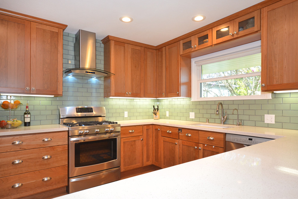 This is an example of a medium sized beach style u-shaped enclosed kitchen in San Francisco with a single-bowl sink, shaker cabinets, medium wood cabinets, engineered stone countertops, green splashback, ceramic splashback, stainless steel appliances, medium hardwood flooring and no island.