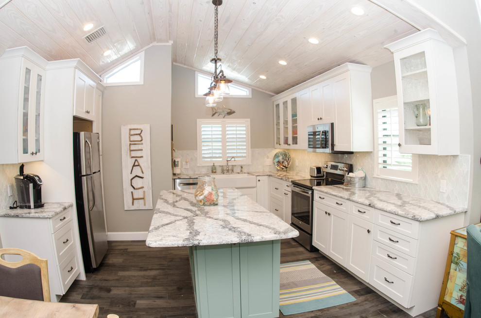 Inspiration for a mid-sized coastal u-shaped dark wood floor open concept kitchen remodel in Tampa with a farmhouse sink, white cabinets, white backsplash, stainless steel appliances, an island, shaker cabinets, marble countertops and porcelain backsplash