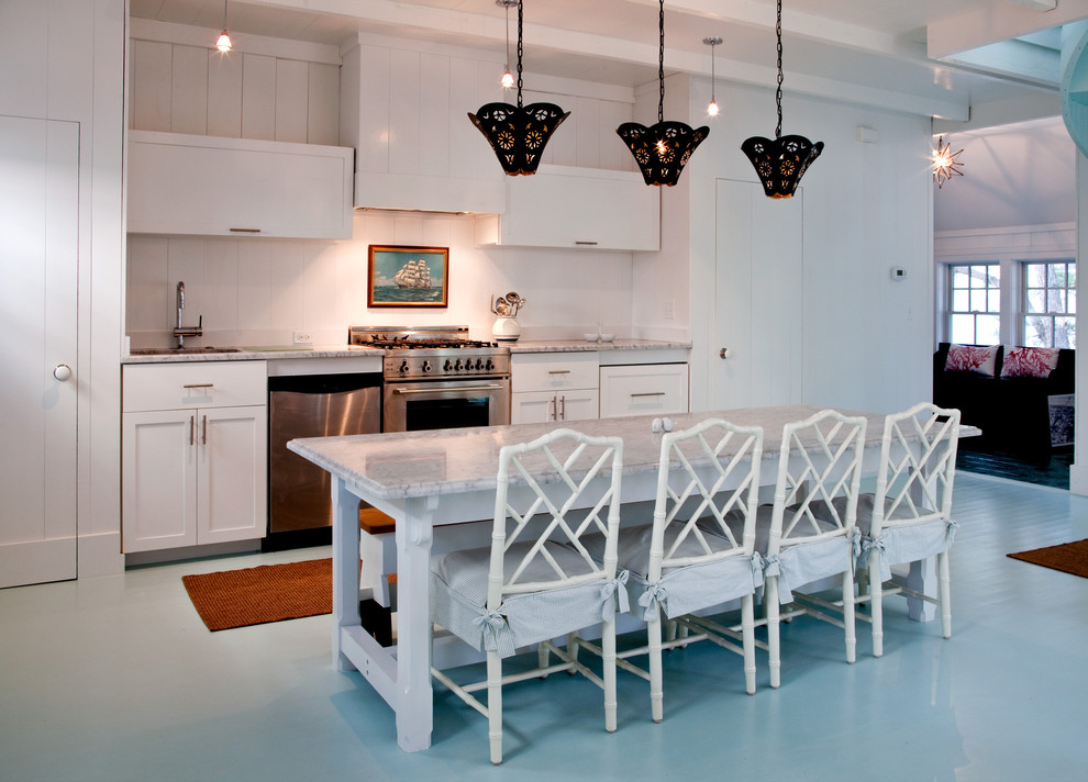 Inredning av ett maritimt kök, med rostfria vitvaror, målat trägolv och blått golv