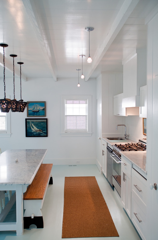 Imagen de cocina costera de obra con electrodomésticos de acero inoxidable y suelo blanco