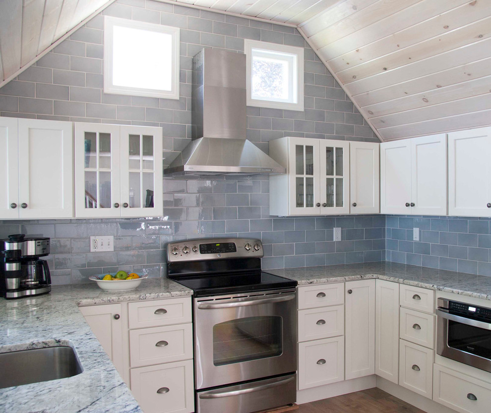 Kitchen - coastal kitchen idea in Providence with recessed-panel cabinets, granite countertops, stainless steel appliances, white cabinets, blue backsplash and ceramic backsplash