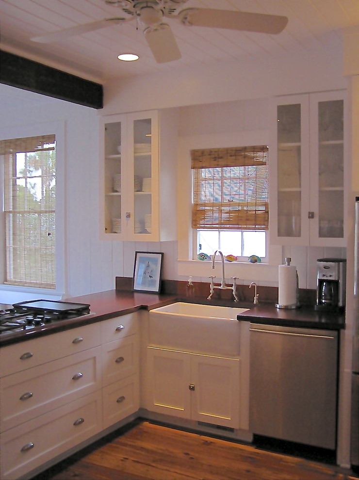 Exempel på ett mellanstort maritimt kök, med en rustik diskho, luckor med infälld panel, vita skåp, träbänkskiva, vitt stänkskydd, rostfria vitvaror, mellanmörkt trägolv och en halv köksö