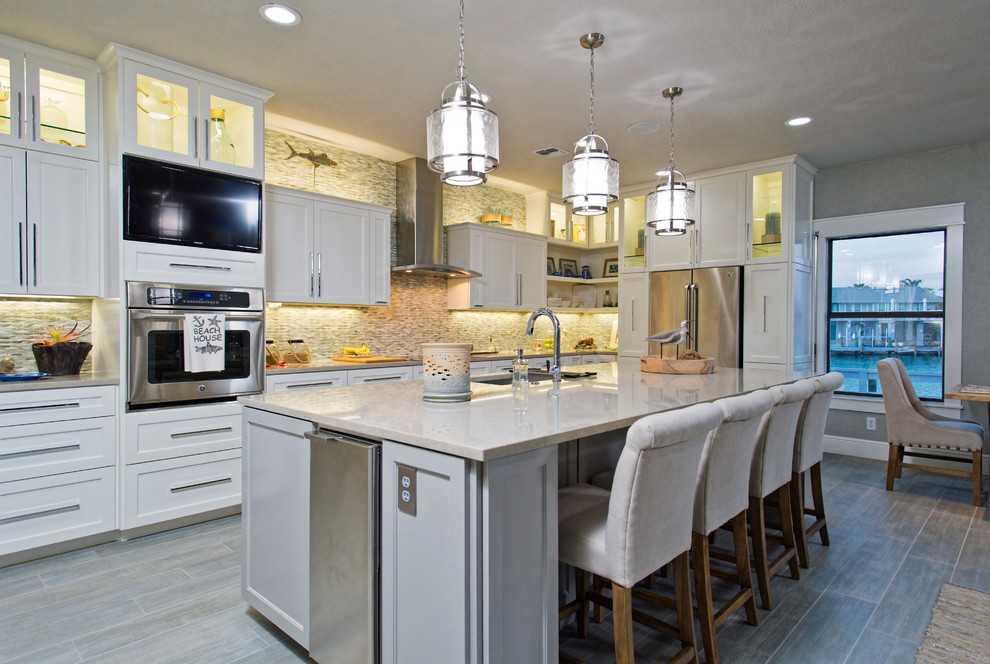 Example of a huge trendy u-shaped porcelain tile open concept kitchen design in Austin with an undermount sink, white cabinets, quartz countertops, multicolored backsplash, glass tile backsplash, stainless steel appliances and an island
