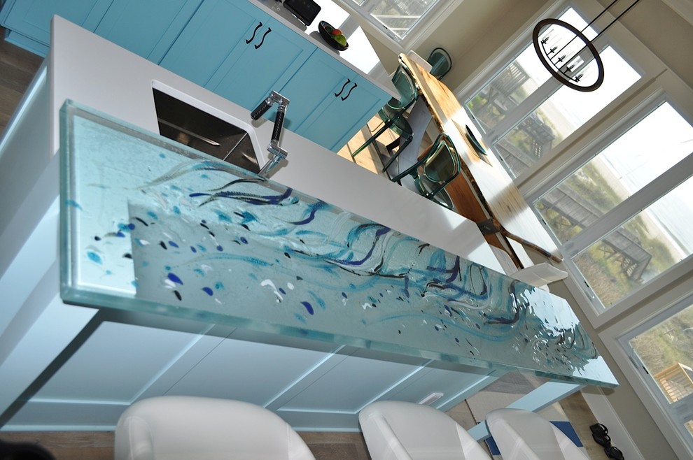 Example of a mid-sized beach style galley light wood floor eat-in kitchen design in Montreal with shaker cabinets, blue cabinets, glass countertops, blue backsplash, stainless steel appliances, no island and an undermount sink