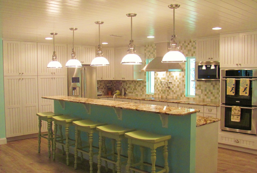 Exempel på ett mellanstort maritimt kök, med en undermonterad diskho, luckor med profilerade fronter, vita skåp, granitbänkskiva, flerfärgad stänkskydd, rostfria vitvaror och laminatgolv