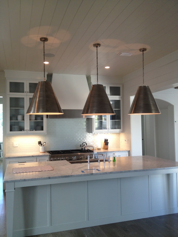 Foto de cocina marinera grande con salpicadero blanco, electrodomésticos de acero inoxidable, una isla y suelo de madera en tonos medios