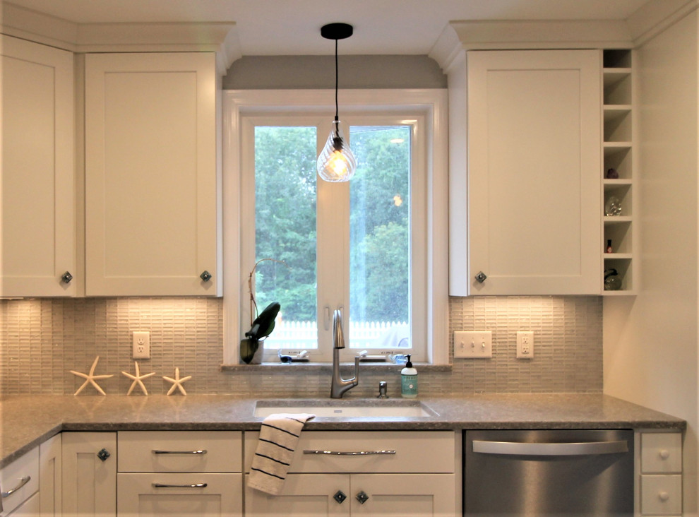 Eat-in kitchen - mid-sized coastal l-shaped vinyl floor and multicolored floor eat-in kitchen idea in Burlington with an undermount sink, shaker cabinets, white cabinets, quartz countertops, gray backsplash, glass tile backsplash, stainless steel appliances, an island and gray countertops