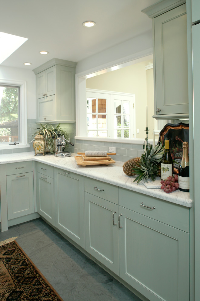 Inspiration for a mid-sized transitional l-shaped enclosed kitchen remodel in San Francisco with a farmhouse sink, shaker cabinets, green cabinets, granite countertops, green backsplash, subway tile backsplash, stainless steel appliances and no island