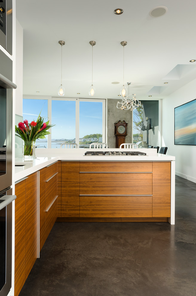Moderne Wohnküche mit flächenbündigen Schrankfronten, hellbraunen Holzschränken und Küchengeräten aus Edelstahl in Vancouver