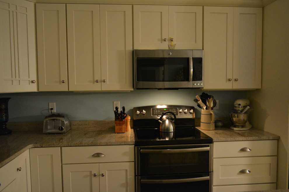 Immagine di una cucina chic di medie dimensioni con lavello a doppia vasca, ante in stile shaker, ante beige, top in granito, elettrodomestici in acciaio inossidabile, pavimento in legno massello medio e top beige