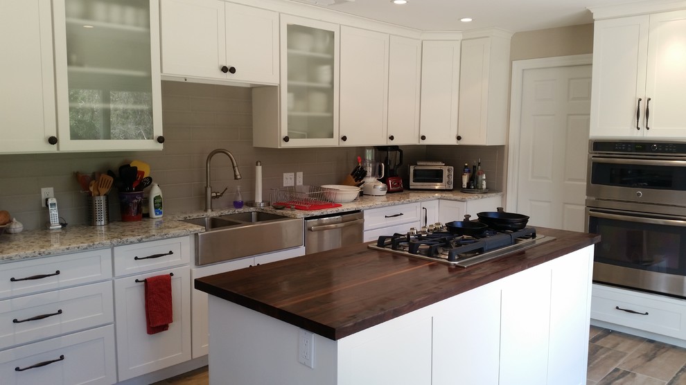 Mid-sized transitional l-shaped porcelain tile eat-in kitchen photo in New York with a double-bowl sink, shaker cabinets, beige cabinets, quartzite countertops, beige backsplash, subway tile backsplash, stainless steel appliances and an island