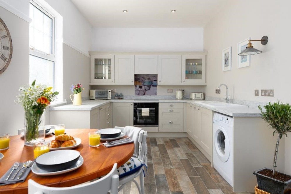 Mittelgroße Klassische Küche in U-Form mit Schrankfronten mit vertiefter Füllung, beigen Schränken, Marmor-Arbeitsplatte, braunem Boden und weißer Arbeitsplatte in West Midlands