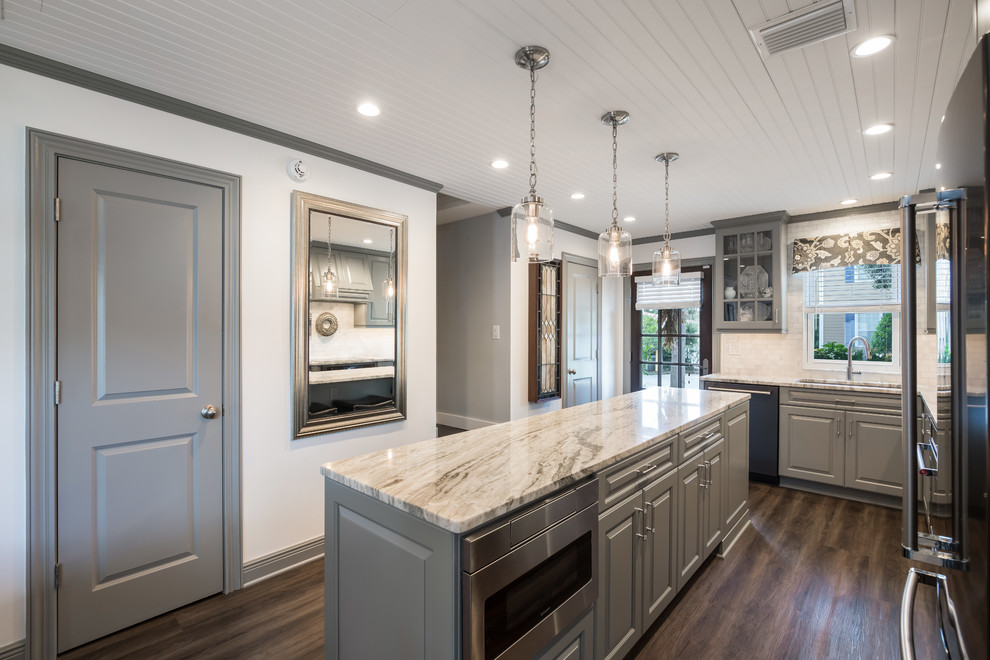 Small arts and crafts l-shaped vinyl floor and brown floor eat-in kitchen photo in Jacksonville with an undermount sink, raised-panel cabinets, gray cabinets, granite countertops, white backsplash, marble backsplash, black appliances, an island and multicolored countertops