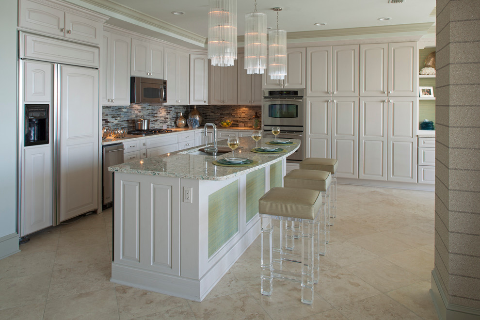 Immagine di una cucina a L stile marinaro con lavello sottopiano, ante con bugna sagomata, ante beige, paraspruzzi multicolore e elettrodomestici da incasso