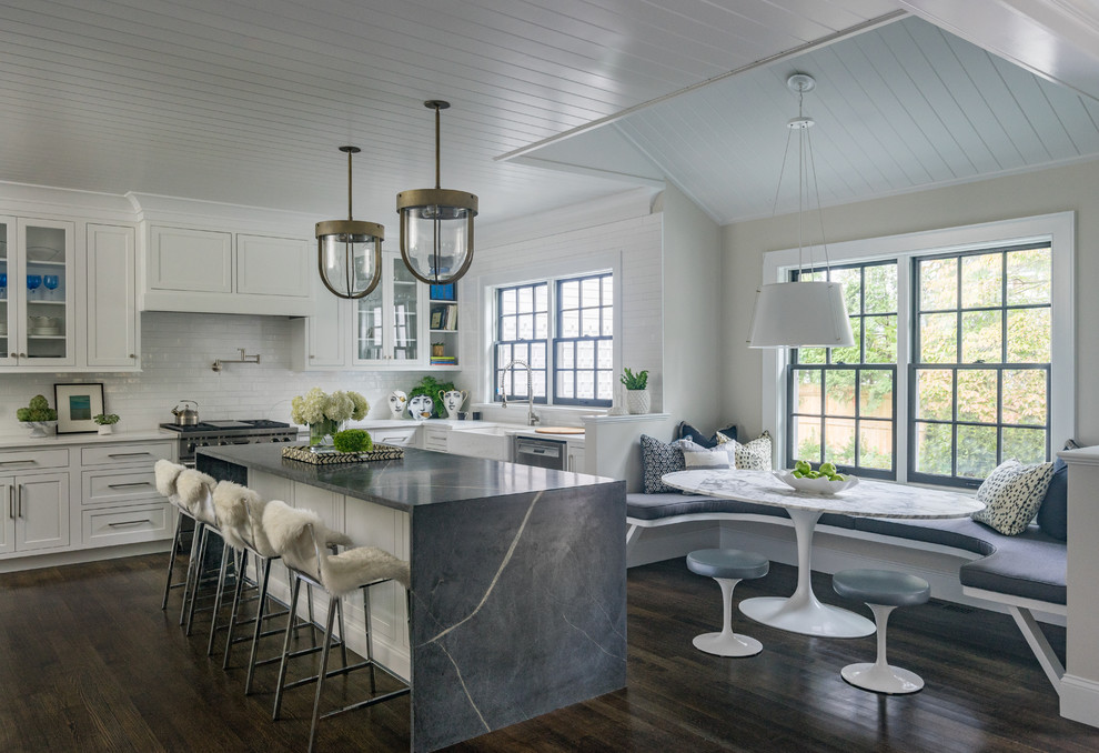 Imagen de cocina comedor marinera con fregadero sobremueble, armarios con paneles empotrados, puertas de armario blancas, salpicadero blanco, electrodomésticos de acero inoxidable, suelo de madera oscura, una isla y suelo marrón