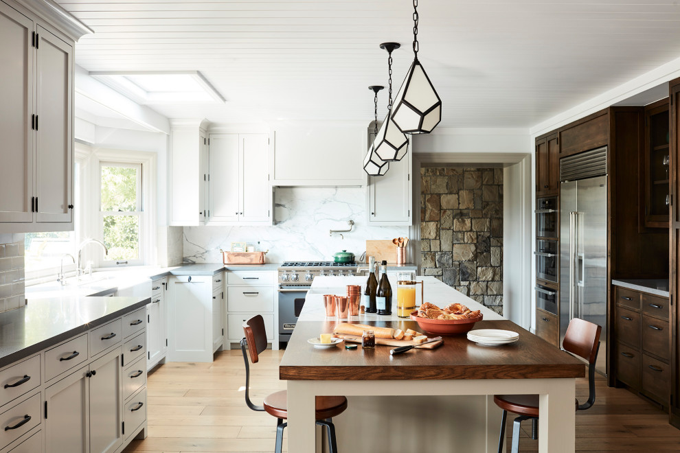 Foto di un cucina con isola centrale stile marinaro con ante in stile shaker, pavimento in legno massello medio e pavimento marrone