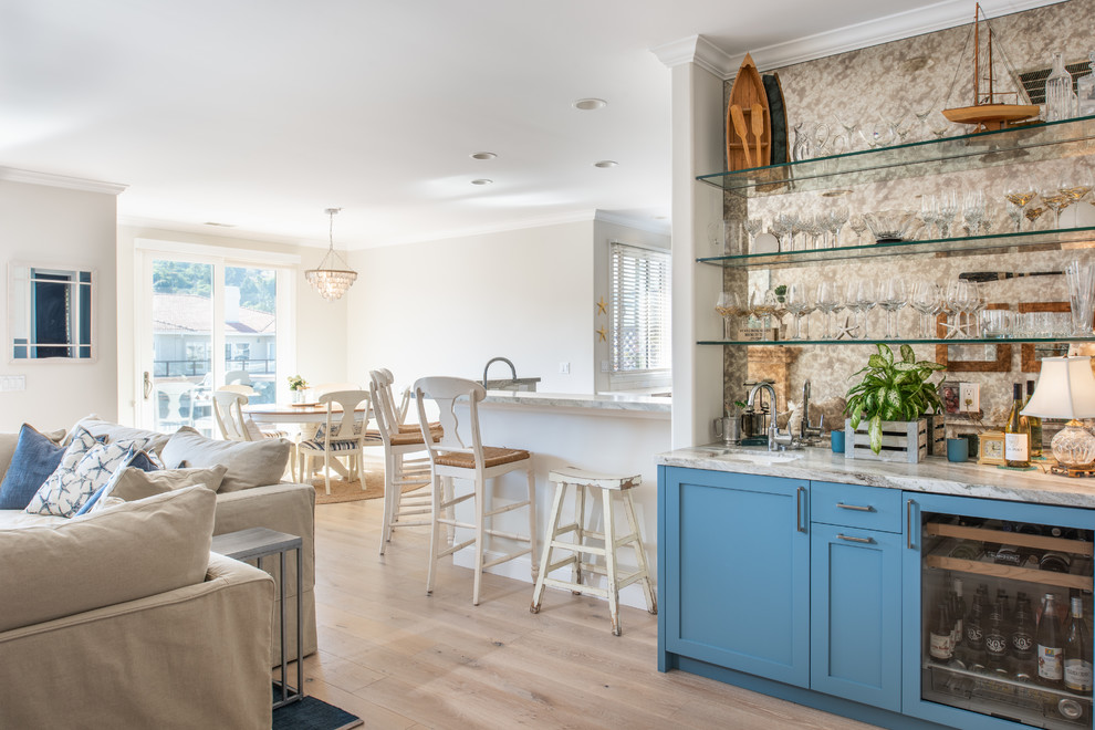 Large transitional u-shaped light wood floor and brown floor open concept kitchen photo in San Francisco with an undermount sink, shaker cabinets, blue cabinets, marble countertops, metallic backsplash, mirror backsplash, paneled appliances, an island and gray countertops