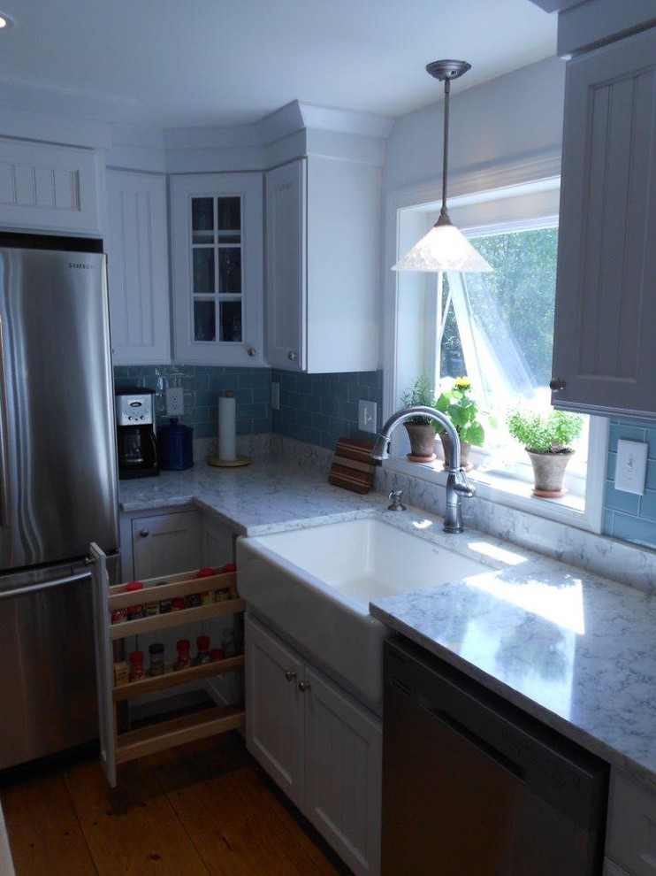 Maritim inredning av ett stort kök, med en rustik diskho, luckor med lamellpanel, vita skåp, marmorbänkskiva, blått stänkskydd, stänkskydd i tunnelbanekakel, rostfria vitvaror, mellanmörkt trägolv och en köksö
