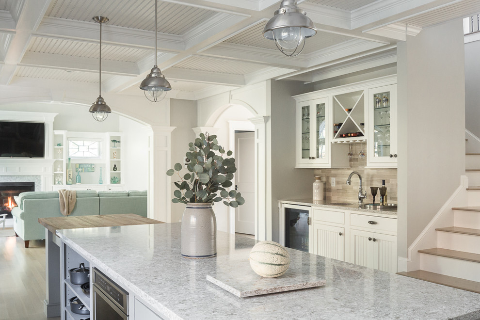 Example of a large arts and crafts l-shaped light wood floor open concept kitchen design in Portland Maine with white cabinets, brown backsplash, stainless steel appliances, an island, granite countertops and shaker cabinets