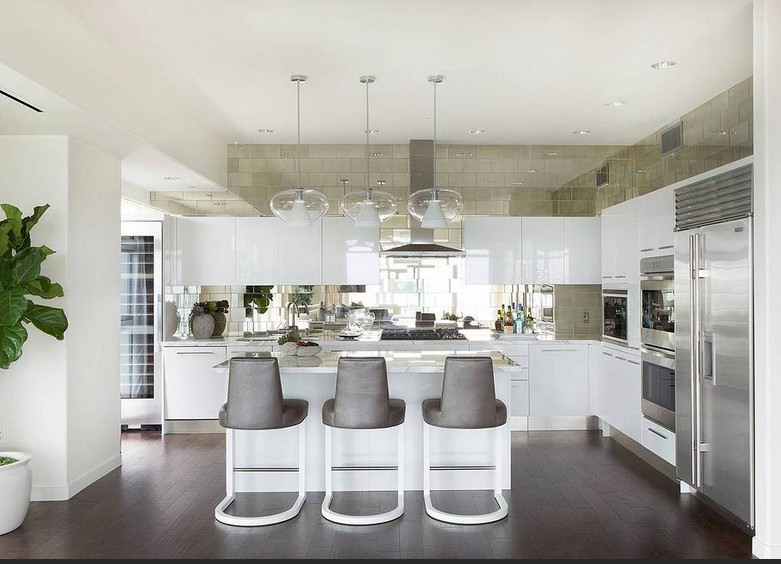 Exempel på ett stort modernt kök, med en undermonterad diskho, släta luckor, vita skåp, marmorbänkskiva, vitt stänkskydd, spegel som stänkskydd, vita vitvaror och mörkt trägolv
