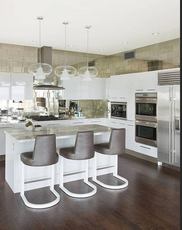 This is an example of a large contemporary u-shaped open plan kitchen in Los Angeles with a submerged sink, flat-panel cabinets, white cabinets, marble worktops, white splashback, mirror splashback, white appliances and dark hardwood flooring.