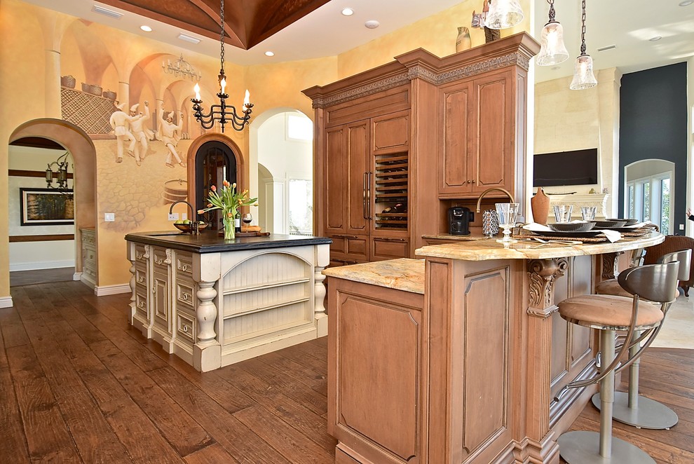 Huge tuscan single-wall dark wood floor and brown floor eat-in kitchen photo in Tampa with raised-panel cabinets, distressed cabinets, granite countertops and glass tile backsplash