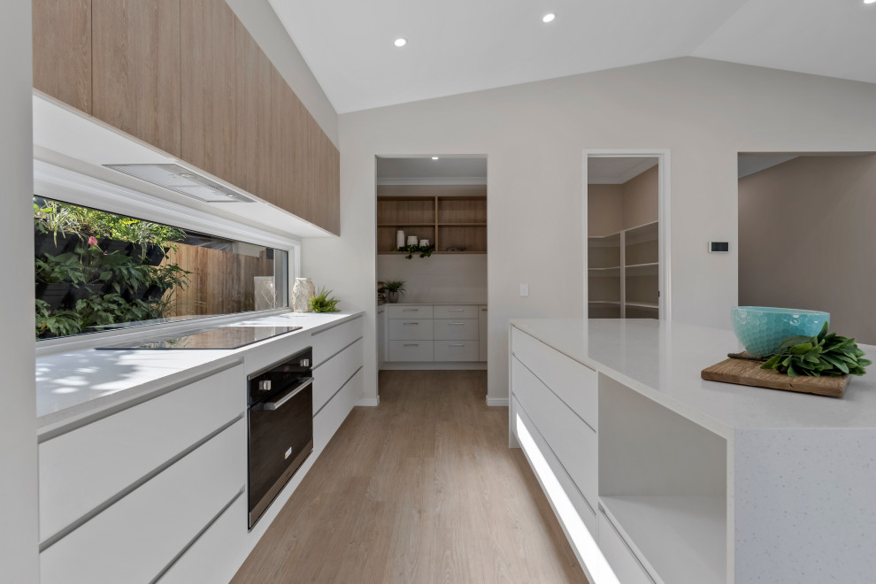 Design ideas for a large beach style galley kitchen in Sunshine Coast with a submerged sink, engineered stone countertops, window splashback, stainless steel appliances, vinyl flooring, beige floors, white worktops and a vaulted ceiling.